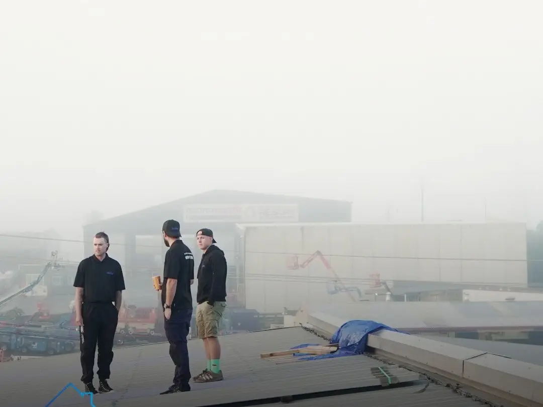 Three of the Exo Roofing crew having a coffee on a roof before the day starts